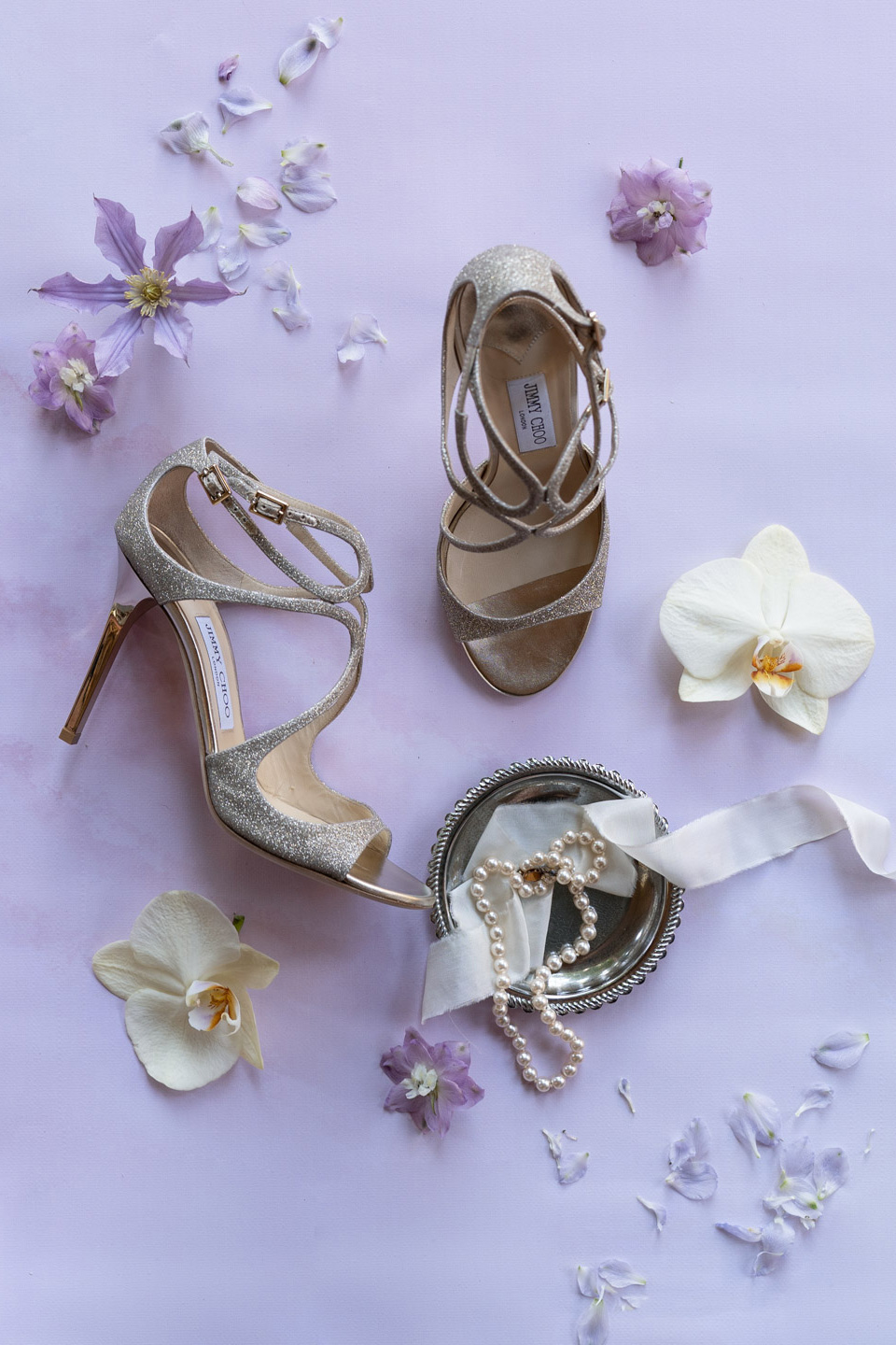 détails de la mariée : chaussures de luxe, bijoux et fleurs